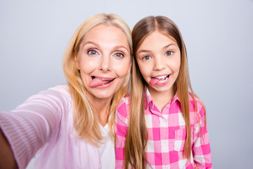 Canvas Print - Close up photo cheer two people blond haired she her granny little daughter make take selfies tongue out mouth weekend wear pink plaid checkered shirt sweater pullover isolated light grey background