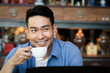© nuiiko - Happy Asian man drinking hot coffee in cafe, lifestyle concept.