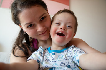 Wall Mural - Selfie of cute small boy with Down syndrome with his mother