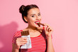 © deagreez - Close-up portrait of her she nice-looking cute charming attractive winsome lovely cheerful girl in striped t-shirt biting tasting eating desirable dessert isolated over pink pastel background