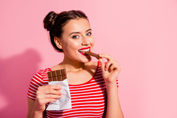 Wall Mural - Close-up portrait of her she nice-looking cute charming attractive winsome lovely cheerful girl in striped t-shirt biting tasting eating desirable dessert isolated over pink pastel background