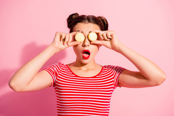 Wall Mural - Close-up portrait of nice cute charming attractive glamorous lovely funny comic teen girl in striped t-shirt covering eyes with colorful delicious snack opened mouth isolated over pink background