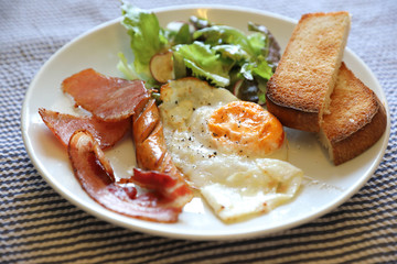 Wall Mural - English breakfast fried egg bacon sausage bread and salad