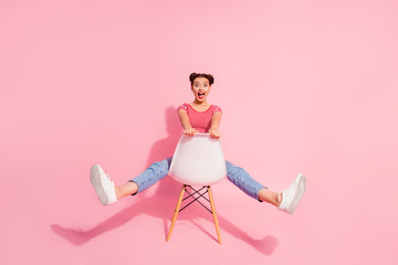 Wall Mural - Nice-looking attractive glamorous lovely shine cheerful cheery girl wearing striped tshirt jeans sitting on chair having fun free spare time isolated over pink pastel background