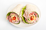 Fototapeta Kuchnia - wrapped tortilla sandwich rolls cut in half