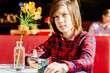 © Iryna - Portrait of teenager boy holding phone and credit card during having breakfast in cafe.