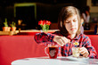 © Iryna - Portrait of teenager boy drinking tea with dessert having breakfast in cafe.