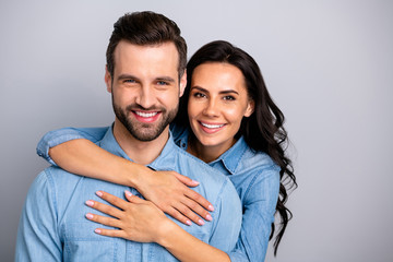 Poster - Portrait of attractive cute beautiful spouses gentle in comfort cozy cuddles showing ideal family marriage bonding wearing blue denim outfit isolated on ashy-gray background