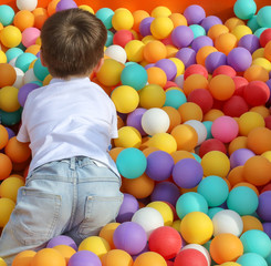 Wall Mural - The boy plays in colorful balls on the attraction