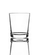 A single empty old fashioned glass isolated on a white background with reflection. High contrast black and white, black line lighting.