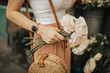 © Olga - Fashionable young blogger girl holding a bunch of flowers at the flower market. Concept of blogging and street style fashion. Summer and spring outfit ideas.
