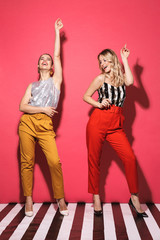 Canvas Print - Full length photo of two young women 20s in trendy outfit smiling and having fun