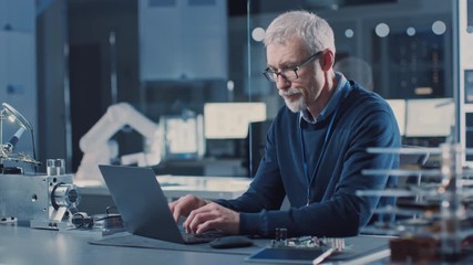 Poster - Professional Electronics Design Engineer Wearing Glasses Works on Computer in Research Facility. In the Background Motherboards, Circuit Boards and Computer Components in the High Tech Facility.