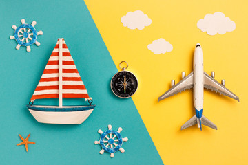 Flat lay sailing ship and airplane on yellow and blue background