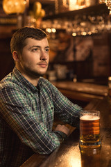 Young man relaxing at the pub having beer