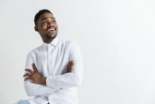 Close Up Portrait Of A Happy Excited Young African American Man Laughing Against Gray Background.