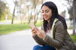 © Mangostar - Smiling young woman texting sms on smartphone