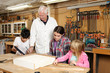 © Cavan Images - Carpenter teaching students in workshop