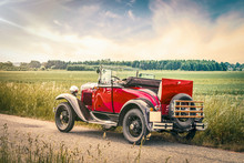 Antique Red Car On A Road In A Countryside Landscape