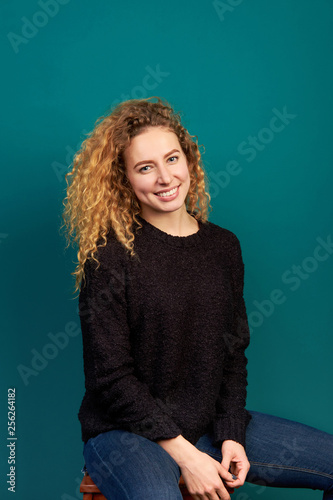 Fotografía Portrait of young attractive smiling cheerful curly ginger girl dressed in black sweater