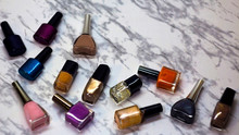 Scattered Nail Polish In The Beauty Salon. The Choice Of Color Nail Polish For Manicure Or Pedicure. Gel Polish For Manicure On A Marble Table.
