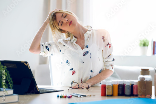 Fotografía Business young woman stretching body for relaxing while working with digital tablet in the office