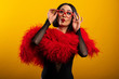 Beautiful Asian woman with vibrant red feather boa and heart shaped glasses, 