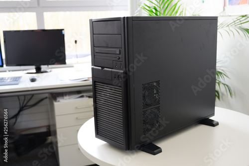 black server computer in a tower case on a white table in the office, selected focus