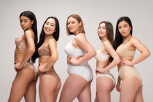 Five Pretty Multiethnic Girls In Lingerie Posing At Camera With Hands On Hips Isolated On Grey, Body Positivity Concept