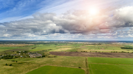 Wall Mural - drone view on the field with a green grass and the village in the distance...