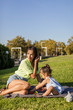 © Westend61 - Happy mother playing with daughter on a blanket in park
