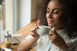 © Nestor - Gorgeous African woman enjoying morning coffee at the local cafe