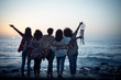 © simona - Romantic and dreamer concept image with five friends women hug each other viewed from back looking at the sunset holiding light - love freedom and wanderlust for group of people
