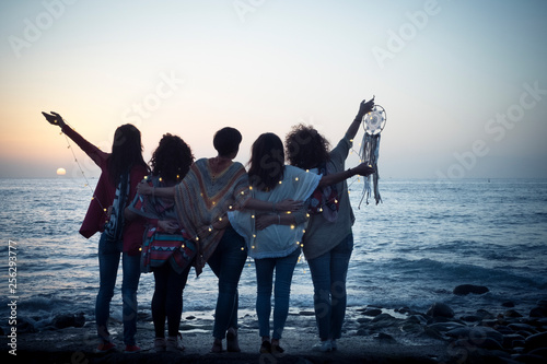Cuadros en Lienzo Romantic and dreamer concept image with five friends women hug each other viewed