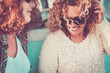 © simona - Couple of young pretty women together with curly blonde hair smile and enjoy the relationship or friendship - vintage color tones filter for middle age beautiful females portrait