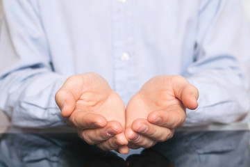 open hands of man sign of begging. man in shirt holding something imaginary on palms of his hands