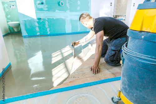 Plasterer During Floor Covering Works With Self Levelling Cement
