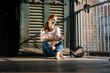 © Westend61 - Smiling businesswoman sitting barefoot on the floor with cup of coffee