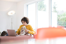 Woman With Dogs Using Laptop At Home