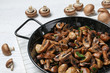 Frying pan with mushrooms on table, closeup