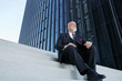 © Westend61 - Elegant businessman, sitting on stairs in the city