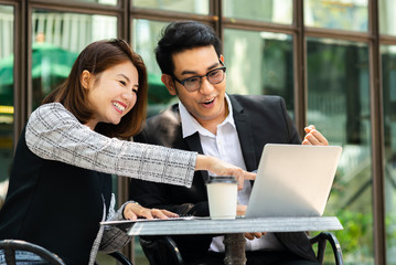 Business woman sitting at cafe outdoor and discussing with her team.