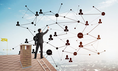 businessman on house roof presenting networking and connection concept. mixed media