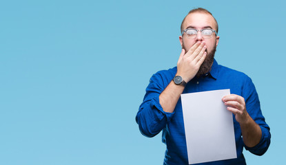 Sticker - Young hipster man wearing glasses and holding blank paper over isolated background cover mouth with hand shocked with shame for mistake, expression of fear, scared in silence, secret concept