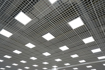 Wall Mural - Ceiling lighting in the form of squares in a large room in a mall or warehouse