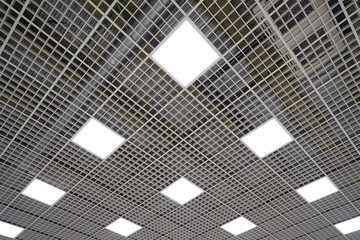 Wall Mural - Ceiling lighting in the form of squares in a large room in a mall or warehouse