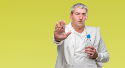 Sticker - Handsome senior man training holding towel and water bottle over isolated background with open hand doing stop sign with serious and confident expression, defense gesture