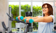 © Syda Productions - sport, healthy lifestyle and old people concept - smiling senior woman with dumbbells and fitness tracker exercising over gym background