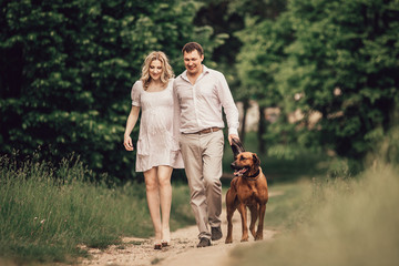 young family and their pet walking along the path in the Park