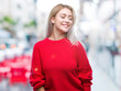 © Krakenimages.com - Young blonde woman wearing winter sweater over isolated background looking away to side with smile on face, natural expression. Laughing confident.